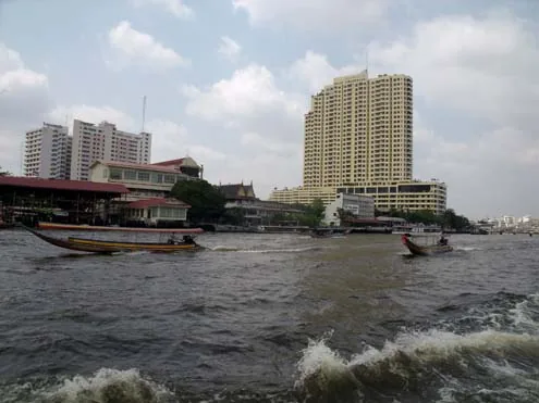 Chao Phraya River flowing past high-rise buildings and boats in central Bangkok