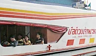 Passengers looking out from the windows of a Chao Phraya Express Boat